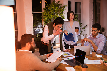 Image showing Colleagues working together in modern office using devices and gadgets during creative meeting