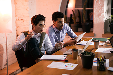 Image showing Colleagues working together in modern office using devices and gadgets during creative meeting