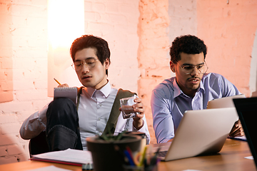 Image showing Colleagues working together in modern office using devices and gadgets during creative meeting