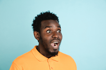 Image showing African man\'s portrait isolated over blue studio background with copyspace