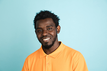 Image showing African man\'s portrait isolated over blue studio background with copyspace