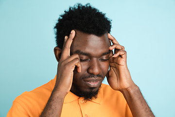 Image showing African man\'s portrait isolated over blue studio background with copyspace