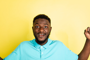 Image showing Portrait of young African man isolated over yellow studio background with copyspace.