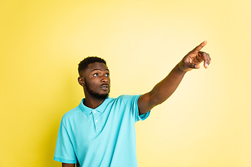Image showing Portrait of young African man isolated over yellow studio background with copyspace.
