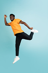 Image showing Full length portrait of African young man isolated over blue studio background with copyspace