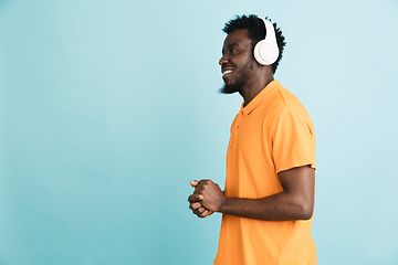 Image showing African man\'s portrait isolated over blue studio background with copyspace