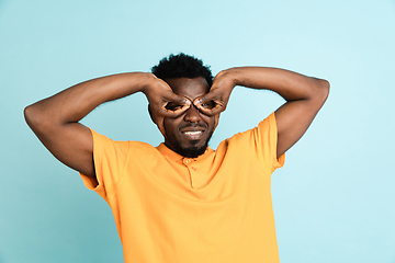 Image showing African man\'s portrait isolated over blue studio background with copyspace