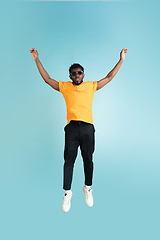 Image showing Full length portrait of African young man isolated over blue studio background with copyspace