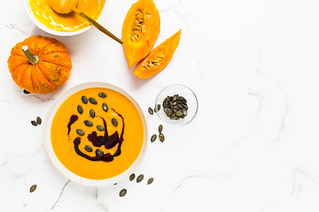 Image showing Homemade pumpkin soup with pumpkin oil and seeds