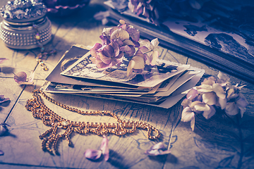 Image showing Memories - old family photo album with necklace, old books and dried flowers