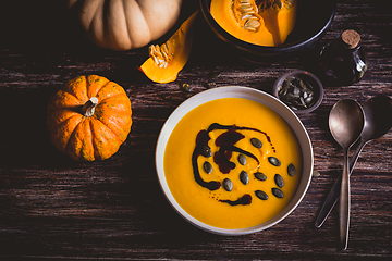 Image showing Homemade pumpkin soup with pumpkin oil and seeds