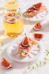 Image showing Small canape snack, crostini with ham, fig and apple wine