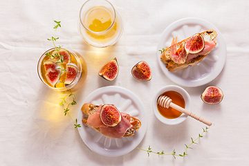 Image showing Small canape snack, crostini with ham, fig and apple wine