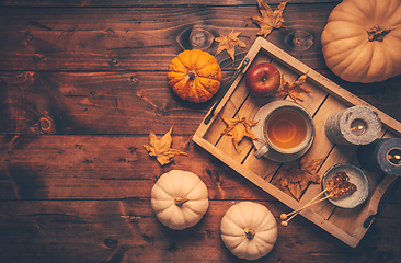 Image showing Hot tea with cookies, apple and fall foliage and pumpkins on woo