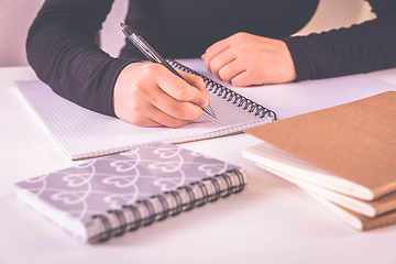 Image showing Detail of hands writing with school supplies