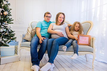 Image showing Family portrait near christmas tree. Pregnant woman