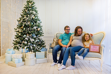 Image showing Family portrait near christmas tree. Pregnant woman