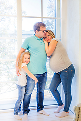 Image showing Beautiful pregnant woman, girl and man near the window