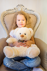 Image showing Cute girl in casual clothes sitting in the armchair