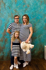 Image showing Family portrait with pregnant woman, girl and man in striped clothes