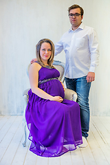 Image showing Pregnant woman in an ultraviolet dress with husband sitting