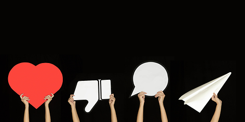 Image showing Hands holding the signs of social media on black studio background, flyer