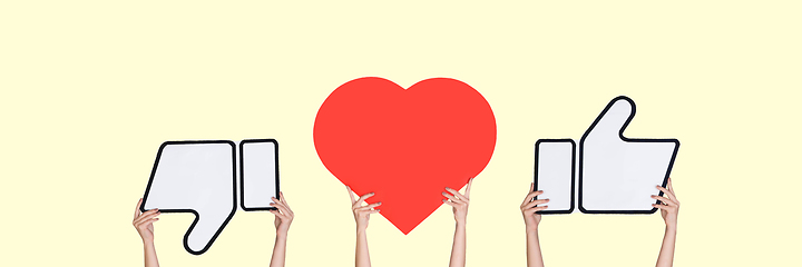 Image showing Hands holding the signs of social media on pastel yellow studio background, flyer