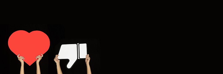 Image showing Hands holding the signs of social media on black studio background, flyer