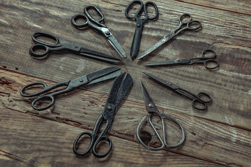 Image showing Vintage steel scissors on wooden table background