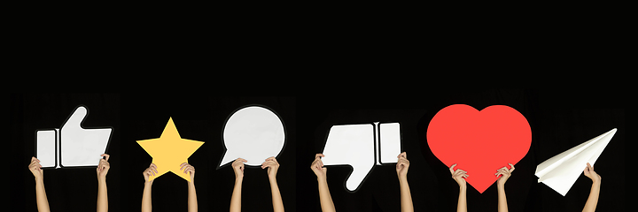 Image showing Hands holding the signs of social media on black studio background, flyer