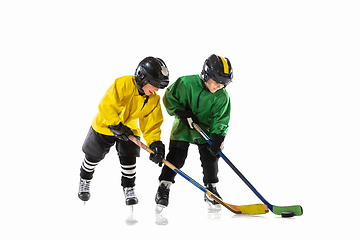 Image showing Little hockey players with the sticks on ice court and white studio background