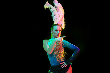 Image showing Beautiful young woman in carnival and masquerade costume in colorful neon lights on black background