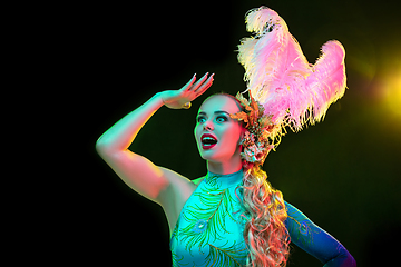 Image showing Beautiful young woman in carnival and masquerade costume in colorful neon lights on black background