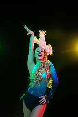 Image showing Beautiful young woman in carnival and masquerade costume in colorful neon lights on black background