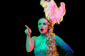 Image showing Beautiful young woman in carnival and masquerade costume in colorful neon lights on black background