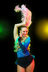 Image showing Beautiful young woman in carnival and masquerade costume in colorful neon lights on black background