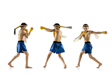 Image showing Little boy exercising thai boxing on white background. Fighter practicing, training in martial arts in action, motion. Evolution of movement, catching moment.