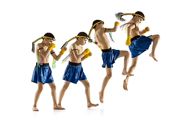 Image showing Little boy exercising thai boxing on white background. Fighter practicing, training in martial arts in action, motion. Evolution of movement, catching moment.