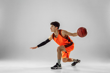 Image showing Young basketball player training isolated on white studio background