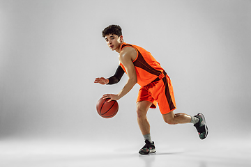 Image showing Young basketball player training isolated on white studio background