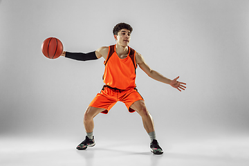 Image showing Young basketball player training isolated on white studio background