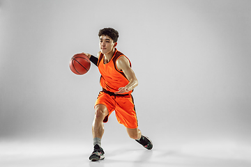Image showing Young basketball player training isolated on white studio background