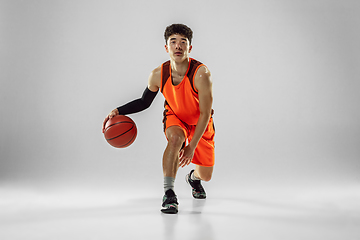 Image showing Young basketball player training isolated on white studio background