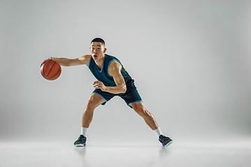 Image showing Young basketball player training isolated on white studio background