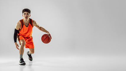 Image showing Young basketball player training isolated on white studio background