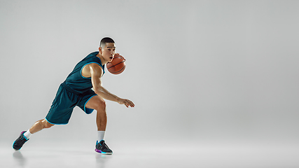 Image showing Young basketball player training isolated on white studio background