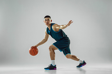 Image showing Young basketball player training isolated on white studio background