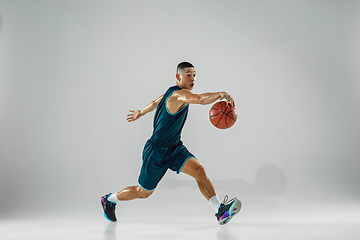 Image showing Young basketball player training isolated on white studio background