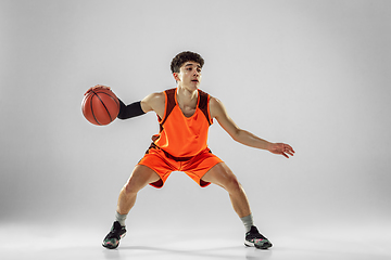 Image showing Young basketball player training isolated on white studio background