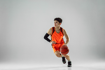 Image showing Young basketball player training isolated on white studio background